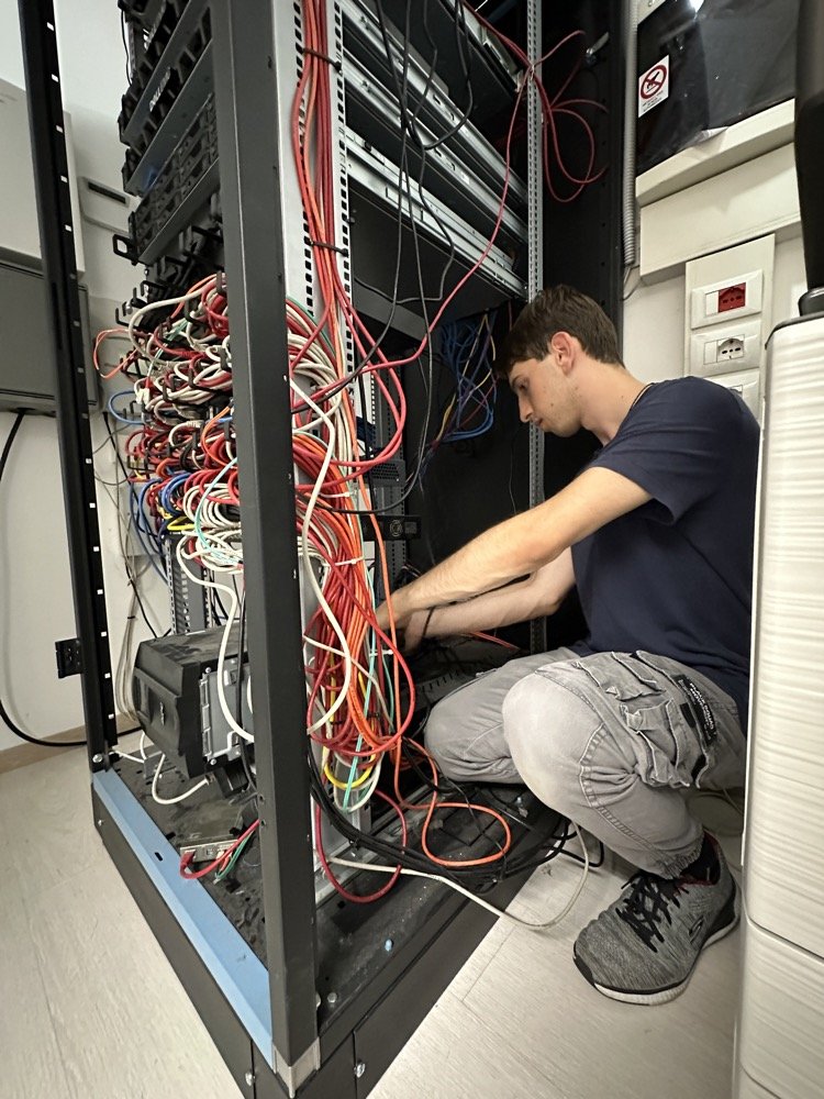 tecnico informatico lavora in armadio di rete